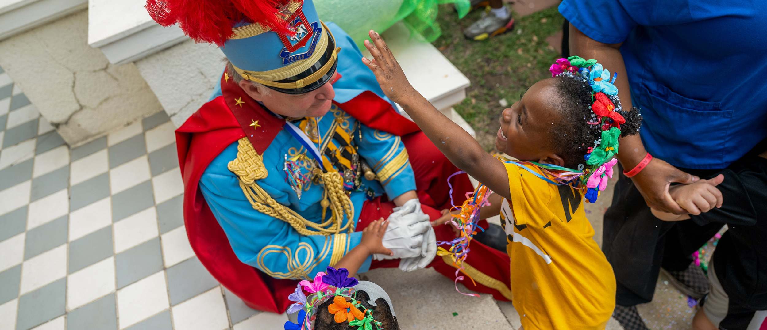 Child reaching for the hat of a Cavalier.