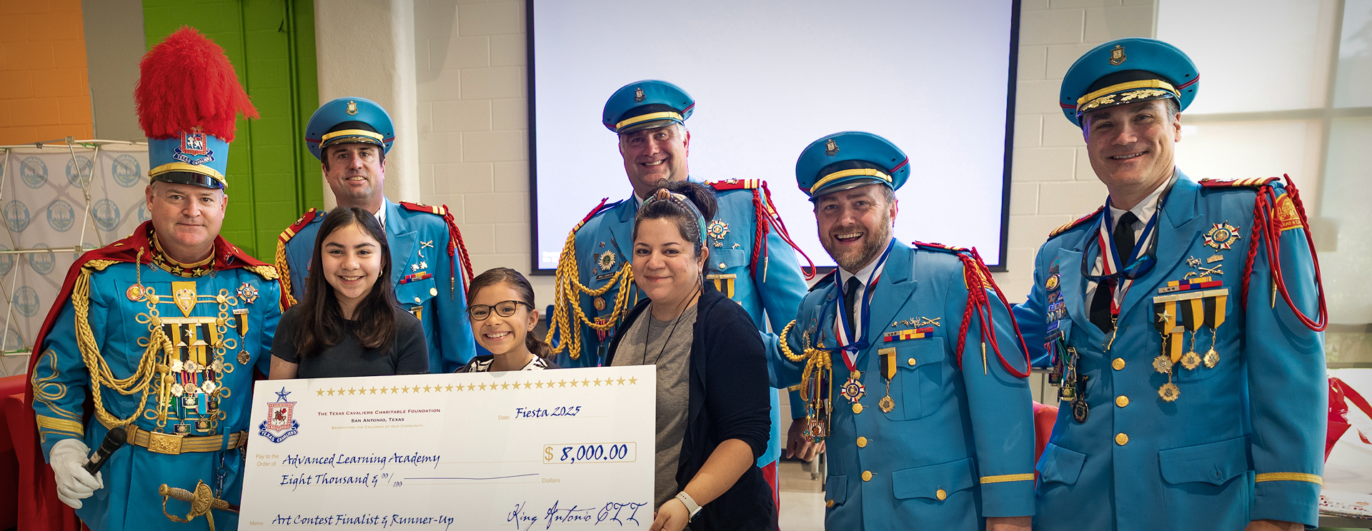 Cavaliers standing with a large check.