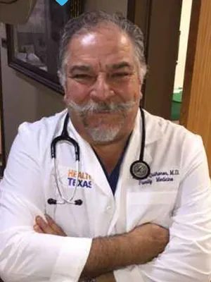 Dr. Manny Qui&ntilde;ones smiles wearing medical jacket and stethoscope